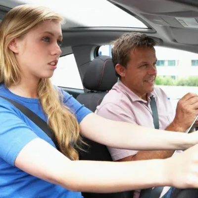 Teenage Girl Taking A Driving Lesson